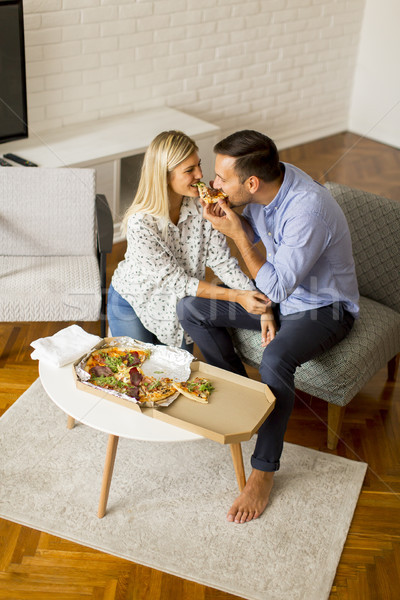 Couple relaxing at home and eating tasteful pizza Stock photo © boggy