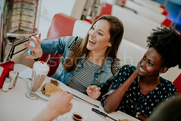 Femenino amigos comer de comida rápida mesa comedor Foto stock © boggy