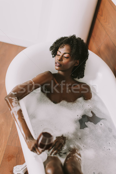 Jonge afro amerikaanse jonge vrouw leggen bad Stockfoto © boggy