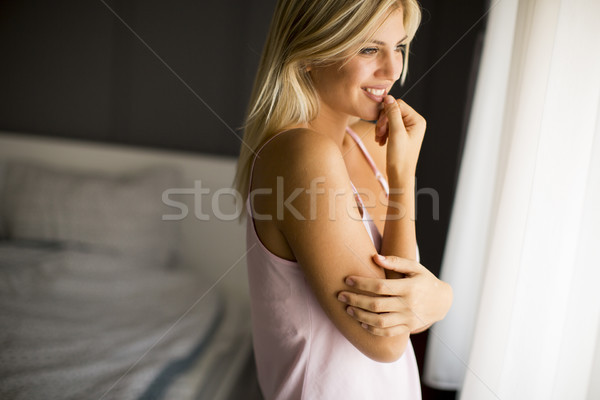 Pretty young woman standing by the window Stock photo © boggy