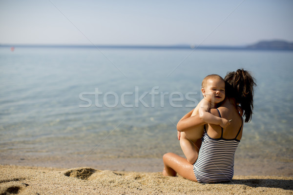 Cute little sisters sitting on a beach Stock photo © boggy