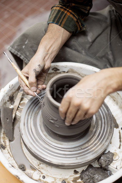 Artist makes clay pottery on a spin wheel Stock photo © boggy