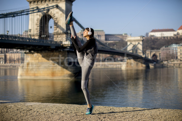 Stock photo: Woman in sportswear stretching on Danube river promenade in Buda