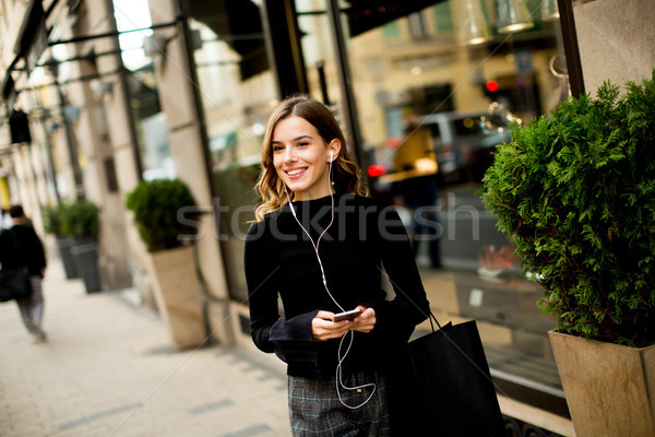 Modern young shopaholic woman on street Stock photo © boggy