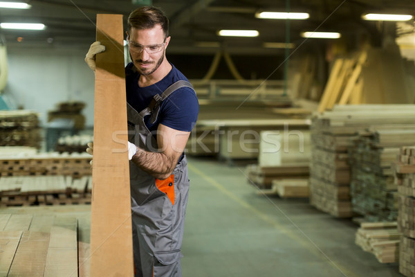 Stock photo: Handsome young man working in the furniture factory