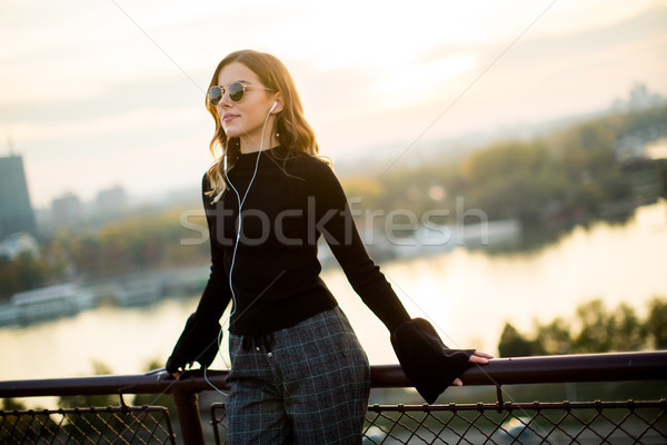 Trendy young woman listening music from smartphone outdoor at su Stock photo © boggy