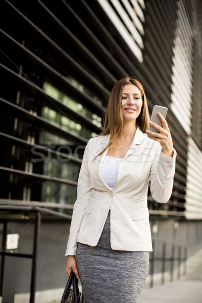 Mujer de negocios teléfono móvil pie edificio de oficinas negocios mujer Foto stock © boggy
