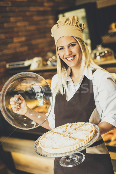 Bakery female worker posing with apple tart in baker shop Stock photo © boggy