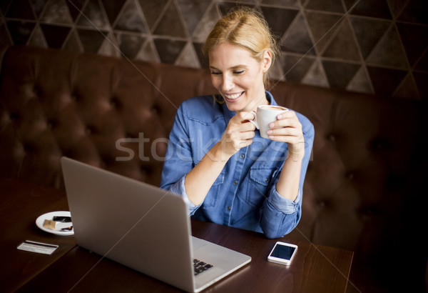 Fiatal nő ül kávézó iszik kávé szörf Stock fotó © boggy