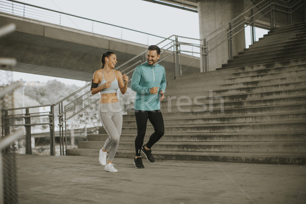 Stock photo: Young couple running in urban enviroment