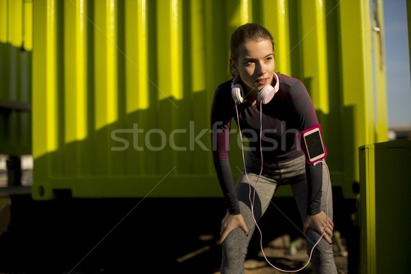 Young attractive female  runner taking break after jogging outdo Stock photo © boggy