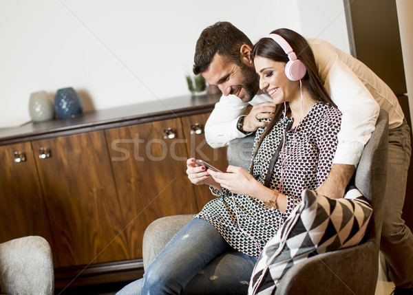 Young woman listening to music from a mobile phone using the han Stock photo © boggy