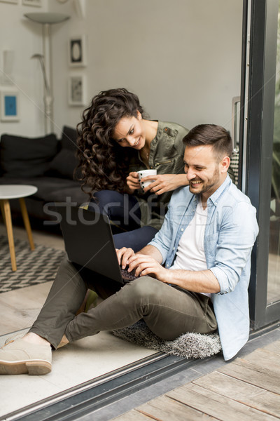 Portrait of a smiling young couple using laptop at home indoor Stock photo © boggy