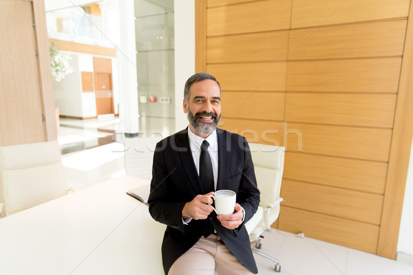 Middle-aged businessman having coffe break in modern office Stock photo © boggy