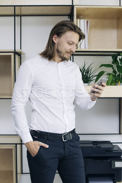 Businessman using mobile phone in the office Stock photo © boggy