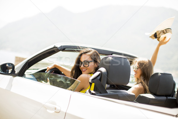 Pretty young women in white cabriolet car Stock photo © boggy