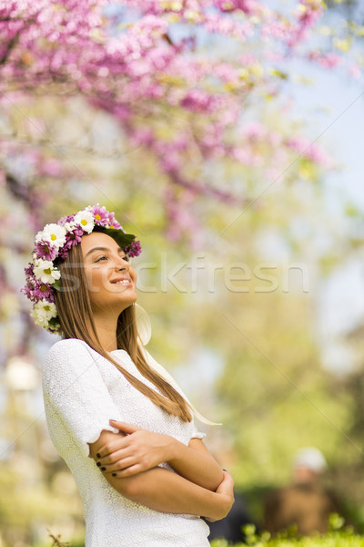 Stock photo: Young woman with flowers in her hair on sunny spring day