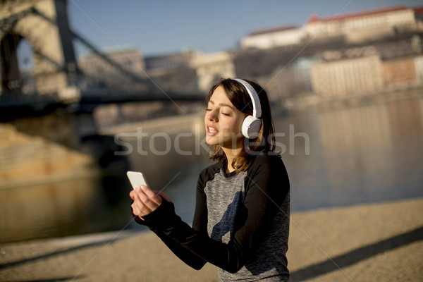 Woman making a pause after the exercise and using mobile phone Stock photo © boggy