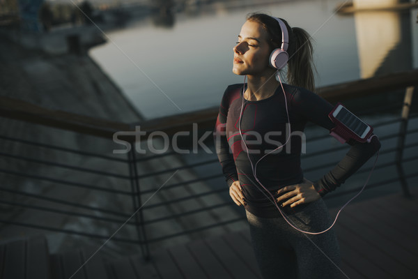 Young attractive female  runner taking break after jogging outdo Stock photo © boggy