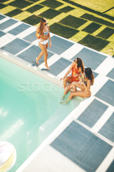 Young women drinking coctail and having fun by swimming pool Stock photo © boggy