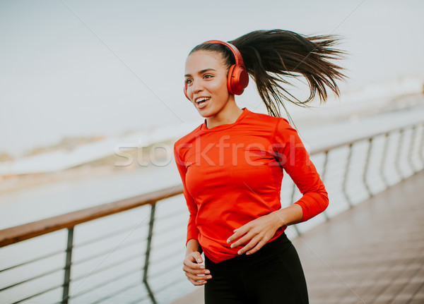 Active young beautiful woman running on the promenade along the  Stock photo © boggy