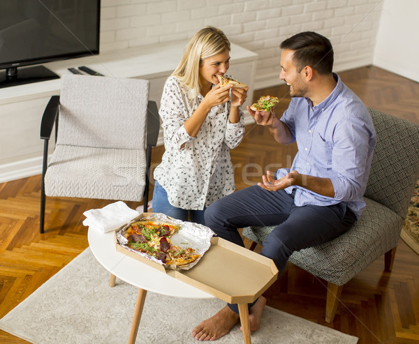 Couple relaxing at home and eating tasteful pizza Stock photo © boggy