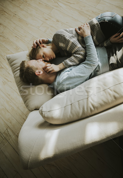 Loving couple lying down on the sofa in the room Stock photo © boggy