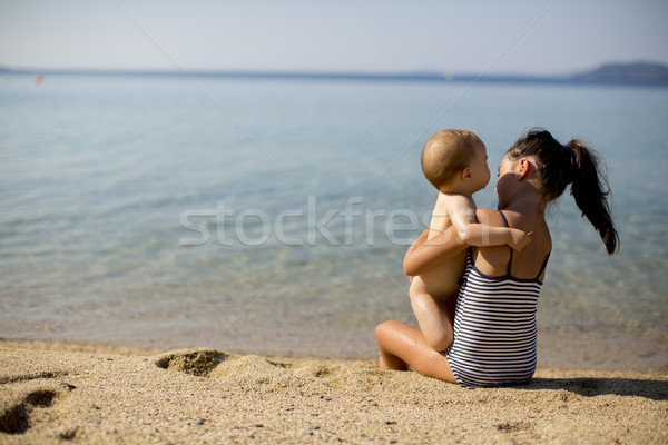 Cute little sisters sitting on a beach Stock photo © boggy