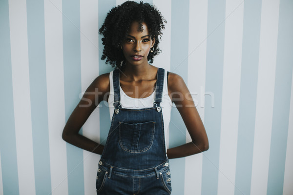 Pretty african american woman posing in jeans trousers Stock photo © boggy