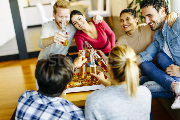 young people eating pizza and drinking cider in the modern inter Stock photo © boggy
