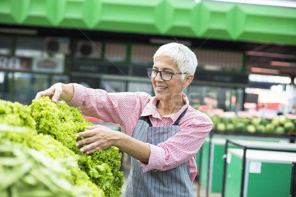 Senior woman sells lettuce on marketplace Stock photo © boggy