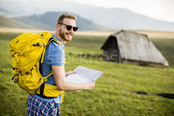 Young redhair man on mountain hiking holding a map Stock photo © boggy