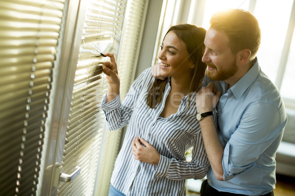 Attractive couple looking trough the room window Stock photo © boggy
