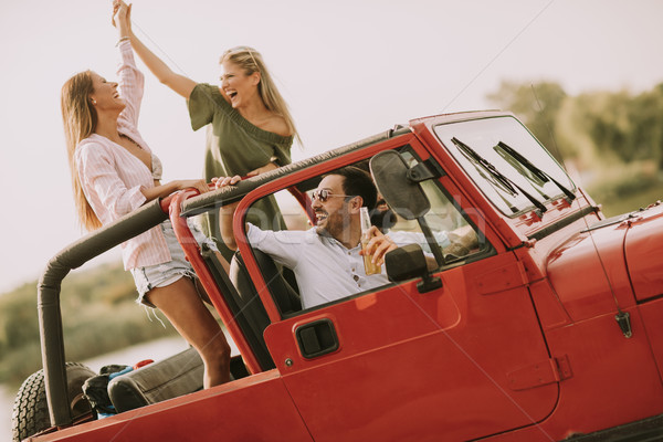 Happy friends having fun in convertible car at vacation Stock photo © boggy