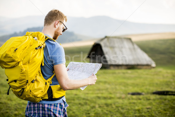 Young redhair man on mountain hiking holding a map Stock photo © boggy