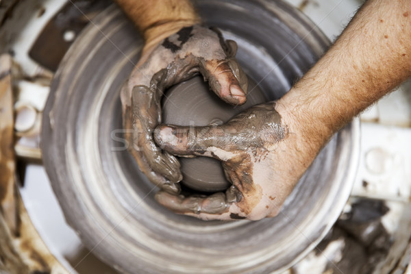 Artist makes clay pottery on a spin wheel Stock photo © boggy