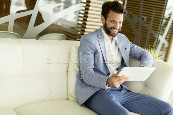 Сток-фото: бизнесмен · таблетка · молодые · деловой · человек · сидят
