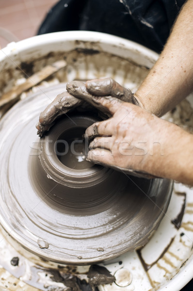 Artist makes clay pottery on a spin wheel Stock photo © boggy