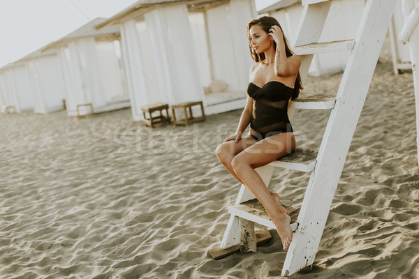 Pretty yung woman sitting on the beach Stock photo © boggy