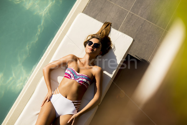 Csinos fiatal nő megnyugtató úszómedence ágy nap Stock fotó © boggy