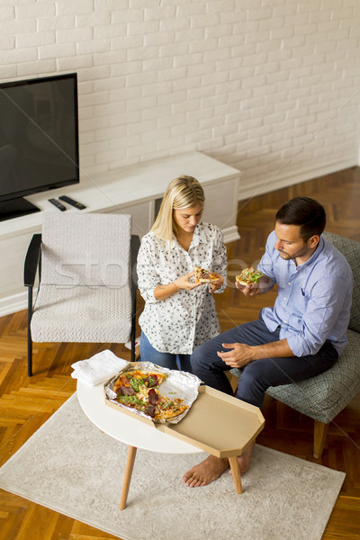 Couple relaxing at home and eating tasteful pizza Stock photo © boggy