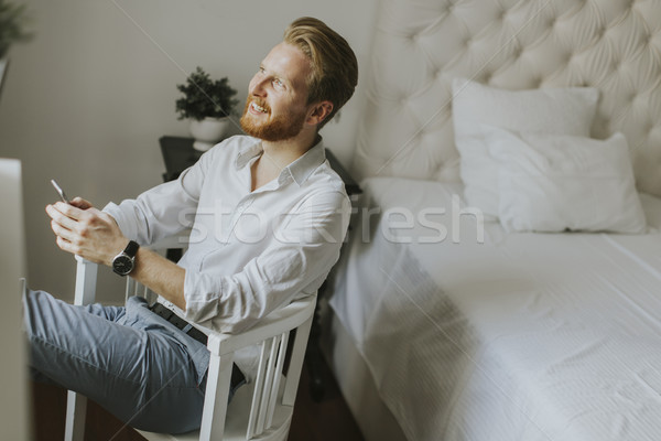 Handsome redhair man writes a message on the phone Stock photo © boggy