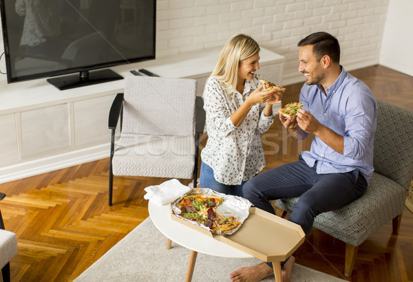 Couple relaxing at home and eating tasteful pizza Stock photo © boggy