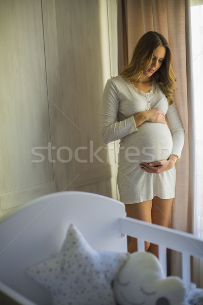 Jeunes femme enceinte berceau chambre joli femme Photo stock © boggy