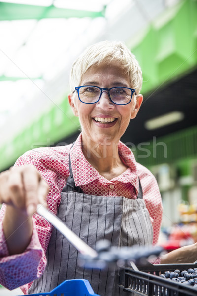 Senior woman sells raspberries on market Stock photo © boggy