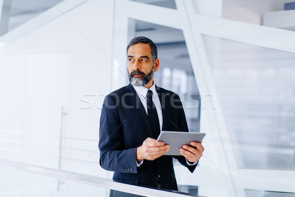 Middle age businessman with tablet in the office Stock photo © boggy