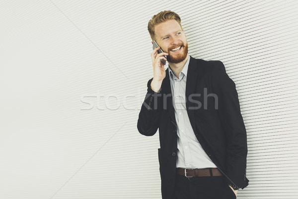 Modern redhair man with mobile phone standing in the office Stock photo © boggy