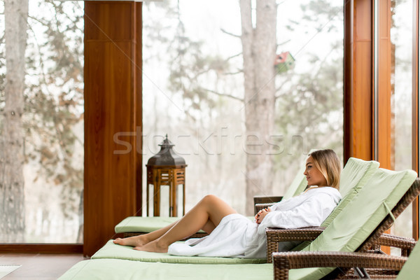 Pretty young woman relaxing on the deckchair by the swimming poo Stock photo © boggy