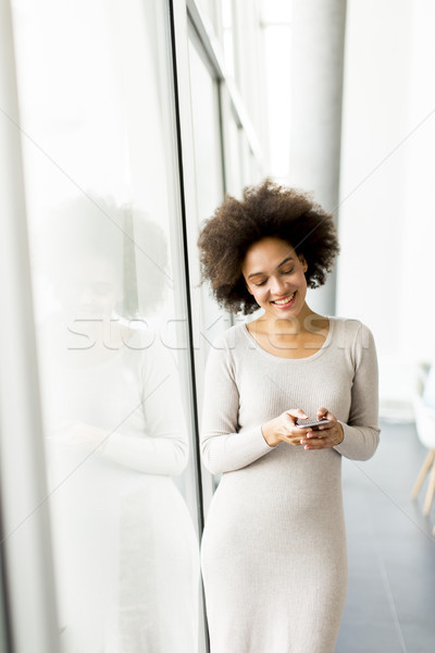 Jonge afro-amerikaanse zakenvrouw mobiele telefoon portret kantoor Stockfoto © boggy