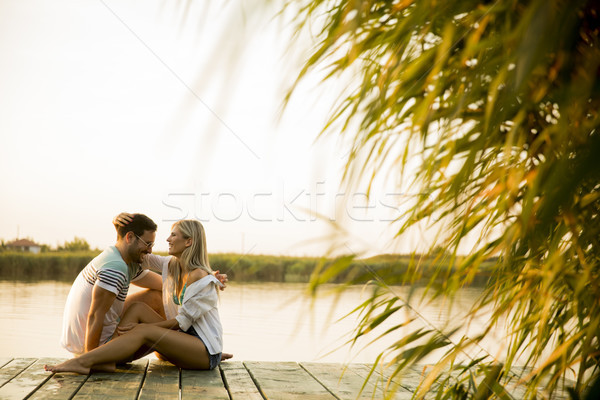 Stock photo: Romantic couple sitting on the wooden pier on the lake